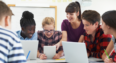 Five middle school students using different devices 